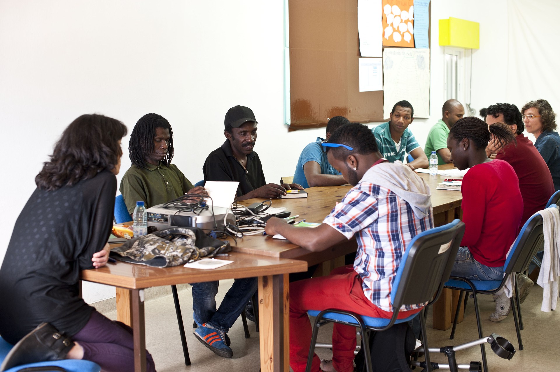 Grupo de participantes numa sessão de formação do Moinho da Juventude, sentados à volta das mesas numa sala